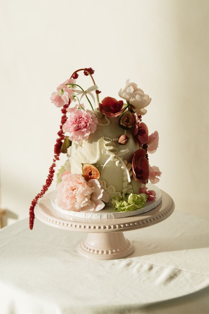Sage cake adorned with figs, peonies and trailing amaranth