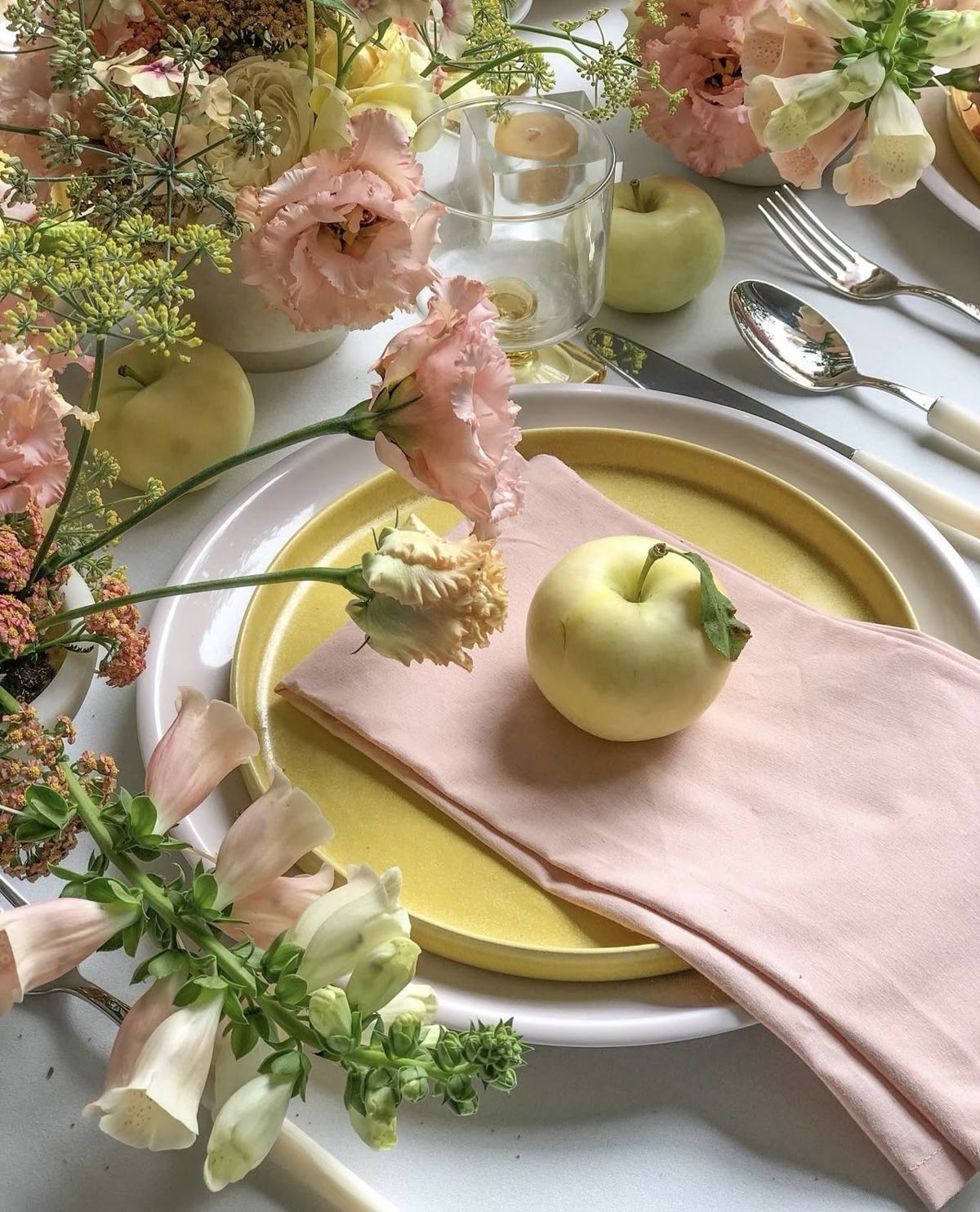 Pastel tablescape with blush napkins, ochre plates and garden florals