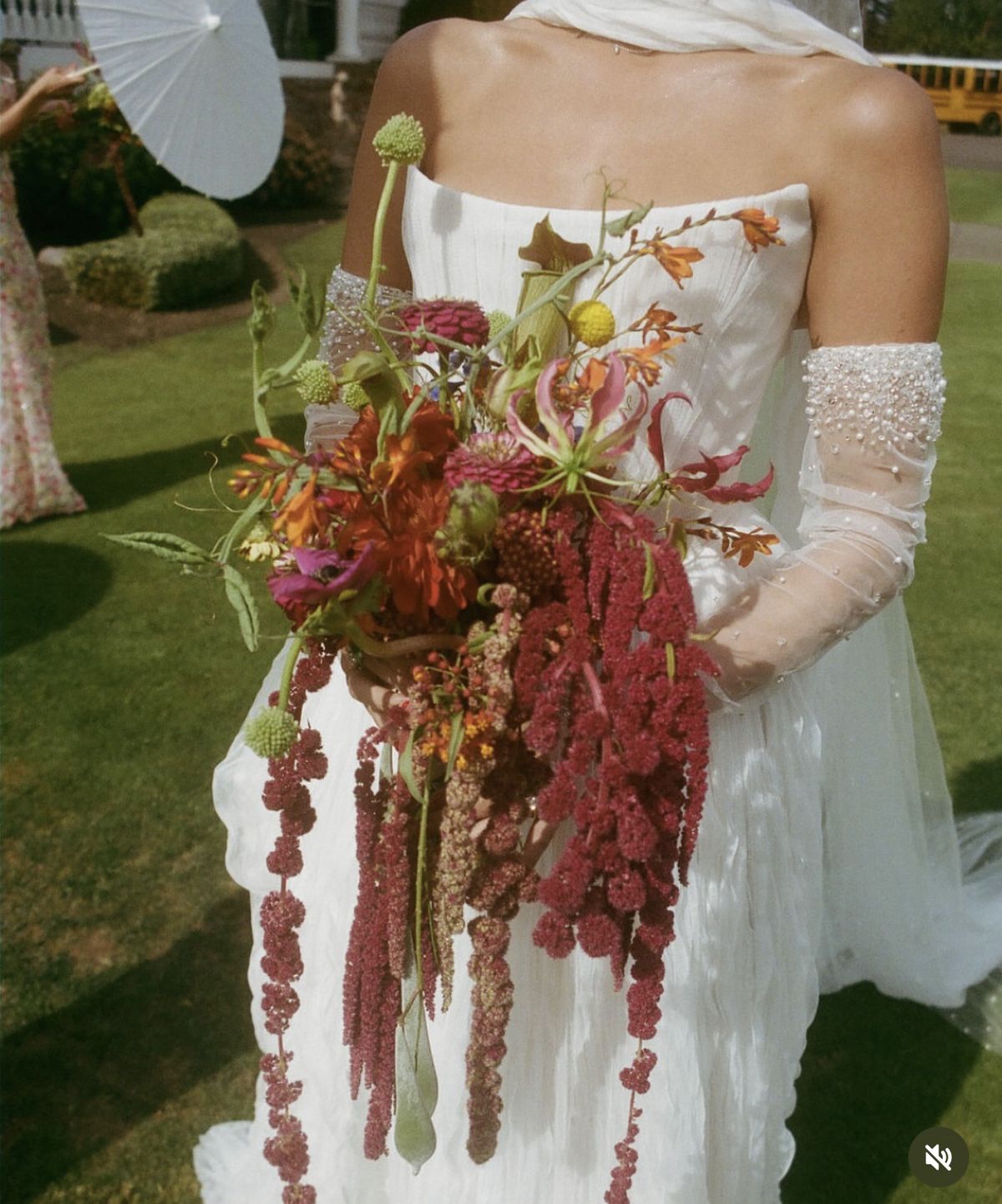 Bride holding a wild bouquet of cream roses and trailing greenery